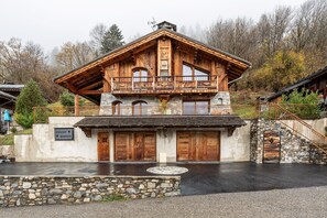 Un chalet doté d’une façade en pierre, de balcons en bois et d’un escalier en pierre.