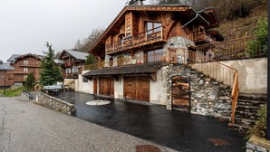 Una casa de madera rústica con una escalera de piedra y un balcón.