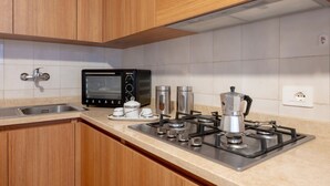 A kitchen with wooden cabinets, a built-in microwave, a gas stove, and a sink.