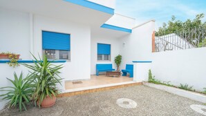 A white building with blue trim, a blue door, and a bench outside.