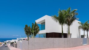 A modern building with a white facade, large windows, and a stone base. - Vacation Villa 'Karat  Murano' with Sea View, Wi-Fi and Air Conditioning (Callao Salvaje)