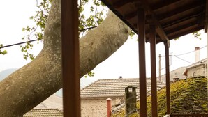 A stone building with a tiled roof, a wooden staircase, and a large tree. - Guest House 'Armoloi Room 2' with Mountain View, Shared Terrace and Wi-Fi (Konitsa)