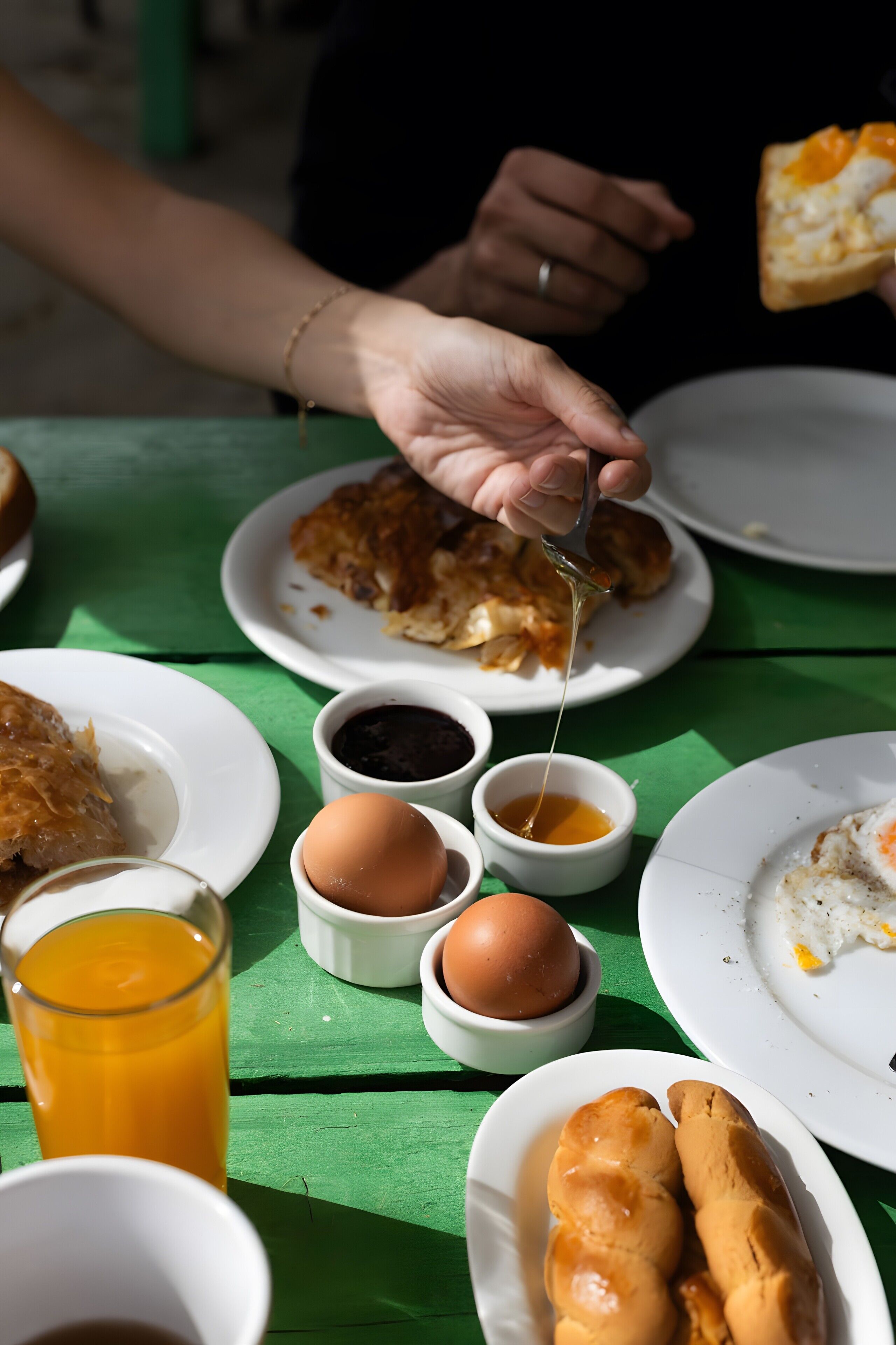 Une table avec des aliments pour le petit-déjeuner, notamment des toasts, des œufs et un verre de jus d’orange.