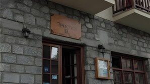 A stone building with a signboard, wooden balcony railings, and a table with chairs outside. - Guest House 'Armoloi Room 6' with Mountain View, Shared Terrace and Wi-Fi (Konitsa)