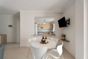 Una cocina moderna con armarios de madera, horno empotrado y ventilador de techo.