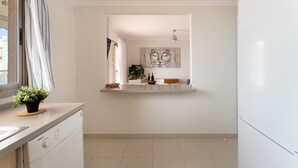 Una cocina moderna con una isla integrada, un refrigerador y un ventanal con cortinas.