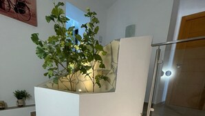 A staircase with wooden steps, a white wall, and a plant on a shelf. - Rural House 'La Morena' with Mountain Views, Wi-Fi, and Air Conditioning (Guaro)