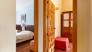 Un dormitorio con una cama, una mesita de noche, una lámpara y un armario de madera.