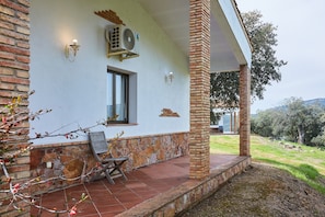 A building with a stone and brick exterior, a window, and an air conditioning unit.