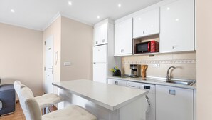 A modern kitchen with white cabinetry, a built-in microwave, and a dishwasher. - Apartment 'Yovalu Con Balcon' with Balcony, Wi-Fi and Air Conditioning (Torrevieja)