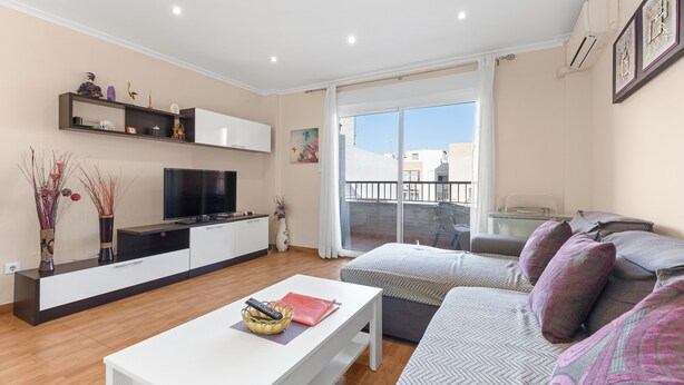 A modern living room with a TV, sofa, and dining table. - Apartment 'Yovalu Con Balcon' with Balcony, Wi-Fi and Air Conditioning (Torrevieja)