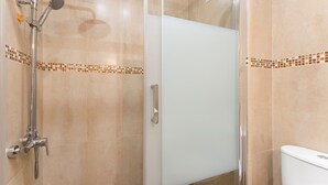 A shower with a handheld showerhead, a wall-mounted showerhead, and a glass-enclosed shower stall. - Apartment 'Yovalu Con Balcon' with Balcony, Wi-Fi and Air Conditioning (Torrevieja)