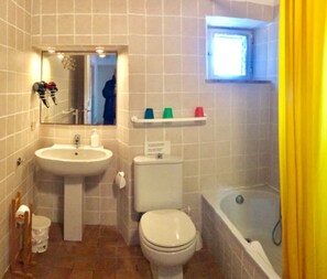 Ein Badezimmer mit Waschbecken, Toilette, Badewanne und Spiegel.