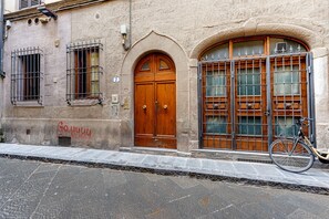 Un bâtiment avec une grande porte en bois, un vélo garé devant et une enseigne portant le numéro 7.