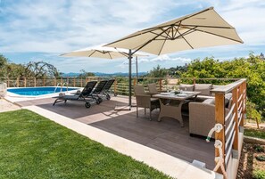 A deck with a pool, outdoor furniture, and a view of the landscape. - Villa 'Ines' with Private Pool, Wi-Fi and Air Conditioning (Illes Balears)