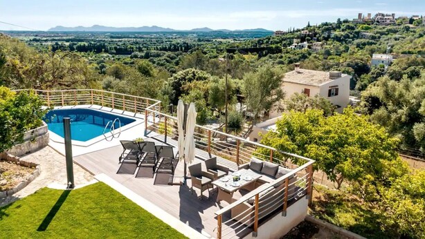 A pool with a view of a hilly landscape, outdoor seating, and a white building. - Villa 'Ines' with Private Pool, Wi-Fi and Air Conditioning (Illes Balears)