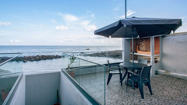 A balcony with a table and chairs, overlooking the sea. - Apartment 'Beach Front Flat' with Sea View, Private Terrace and Wi-Fi (São Vicente)