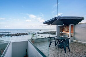 A balcony with a table and chairs, overlooking the sea. - Apartment 'Beach Front Flat' with Sea View, Private Terrace and Wi-Fi (São Vicente)