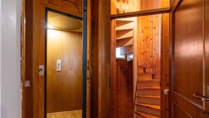 A wooden interior with a staircase, a door with a light switch, and a wall-mounted control panel. - Villa 'Eleonora' with Private Pool, Private Garden and Wi-Fi (San Vivaldo)