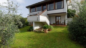 A modern two-story house with a balcony, a well-maintained lawn, and potted plants. - Villa 'Eleonora' with Private Pool, Private Garden and Wi-Fi (San Vivaldo)