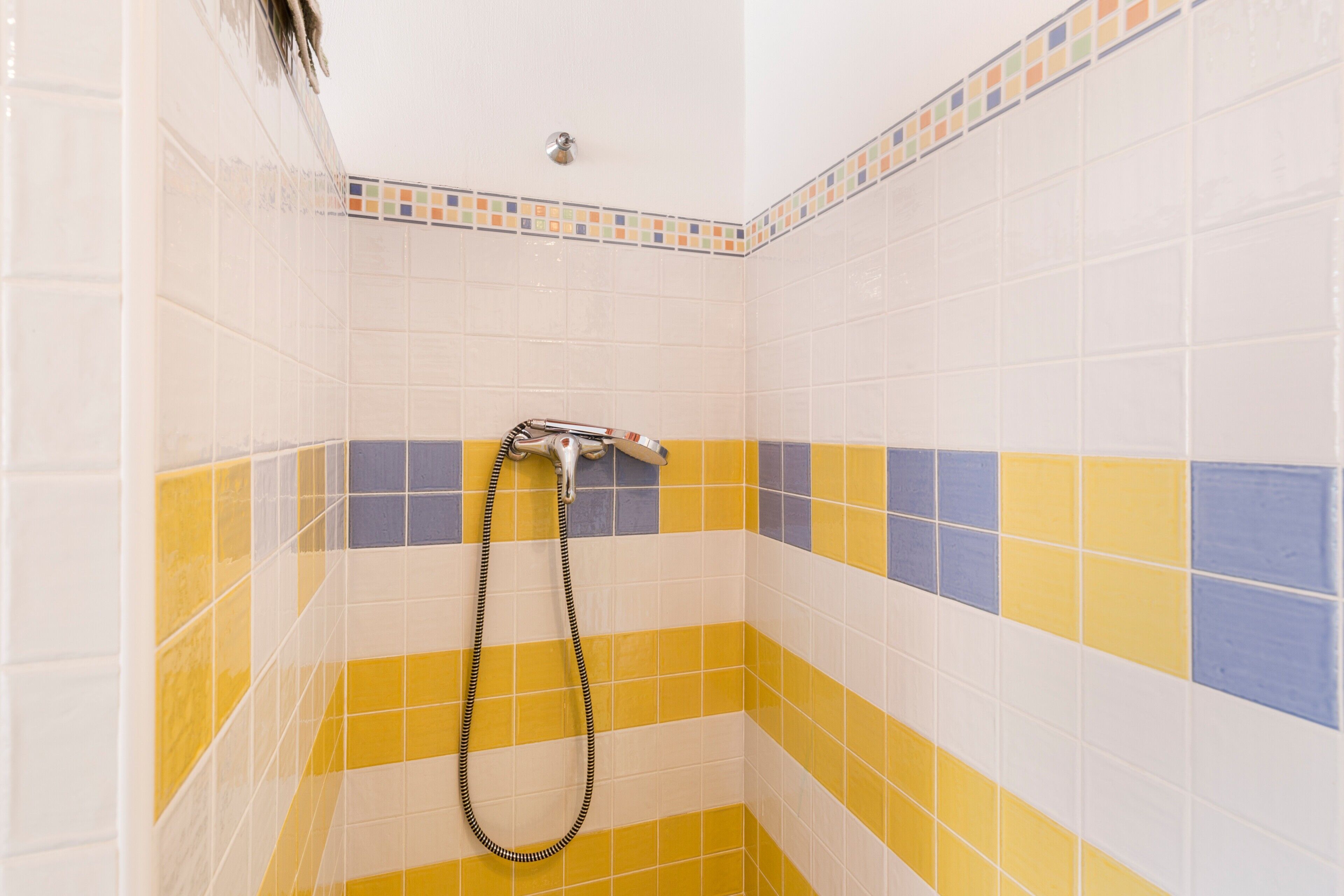 A shower area with tiled walls and a showerhead.