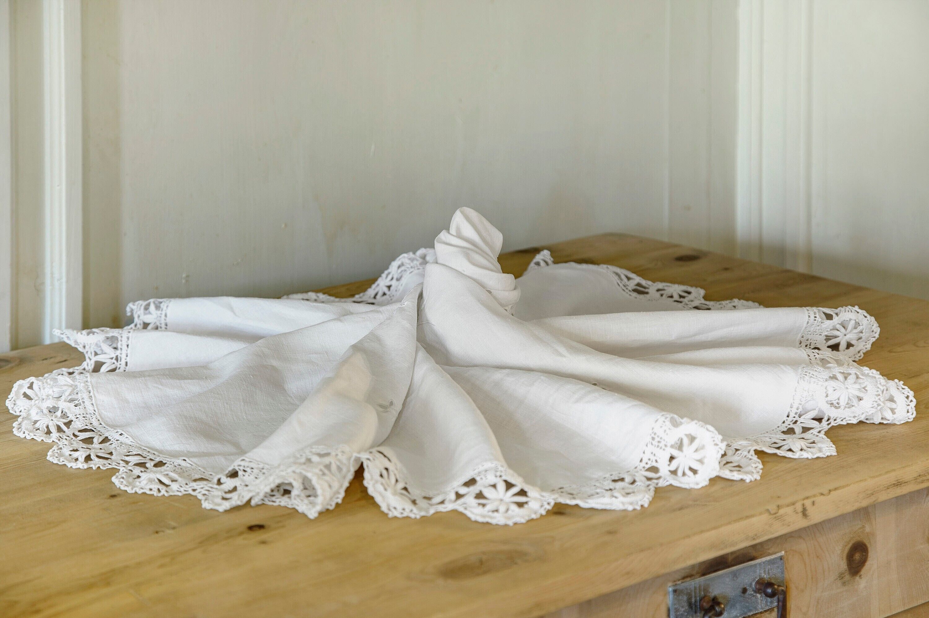 Un tissu de dentelle blanche posé sur une surface en bois.