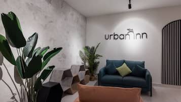 Ein modernes Interieur mit einer Couch, einem Blumentopf und einer Wand mit dem Text 'urbannn'.