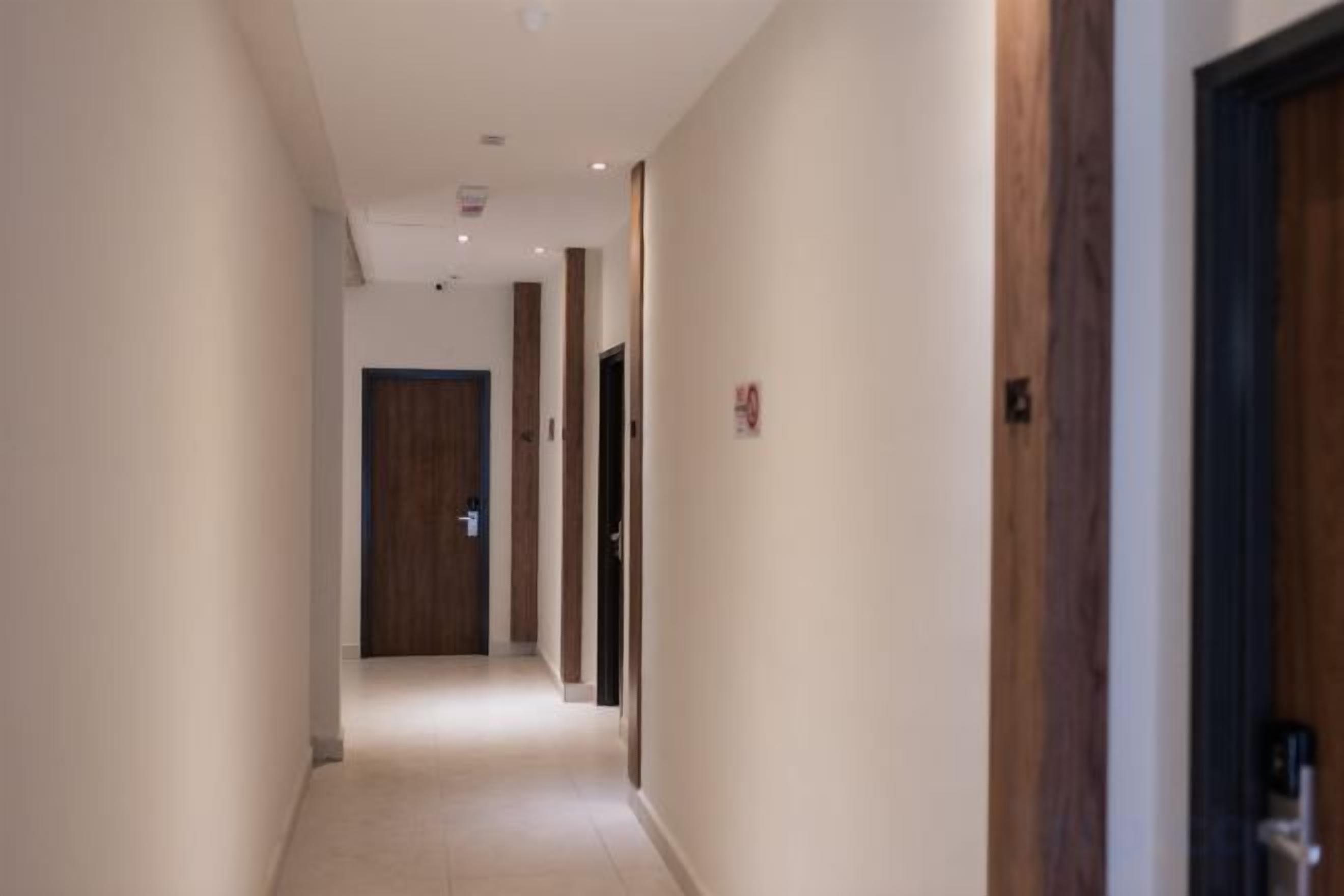 A corridor with doors on both sides, leading to rooms.
