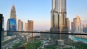 Um edifício alto com fachada curva, rodeado por outros edifícios imponentes e uma paisagem urbana com ruas e áreas verdes.