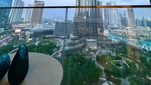 Vista do Burj Khalifa a partir de um edifício alto, com uma mesa e cadeiras em primeiro plano.