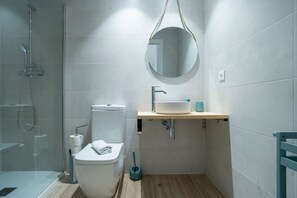 Ein modernes Badezimmer mit Toilette, Waschbecken und Dusche.
