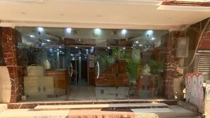 Ein Hotel mit Eingangsbereich, einer Glasfassade, Marmorsäulen und einer Treppe zum Innenraum.