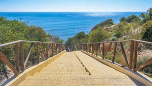 Una escalera de madera que da a vistas de la costa.