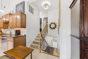 A kitchen with wooden cabinets, a coffee maker, and a dining table. - 2 Level Oceanfront Villa, Sleeps 10, Bunk Room, Zero Entry Pool, Near Coligny (Hilton Head Island)