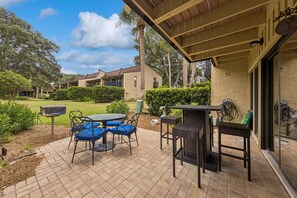 Un patio con tavolo e sedie, una zona relax coperta e vista sul paesaggio circostante.