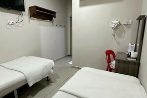 A hotel room with two single beds, a red chair, a wooden nightstand with a white mug, and a wall-mounted TV. - Hotel Lean Fatt (Ipoh)