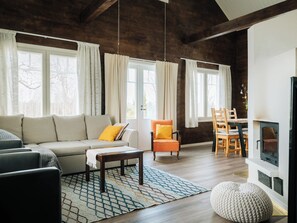 A living room with a sofa, armchairs, a coffee table, and a fireplace.