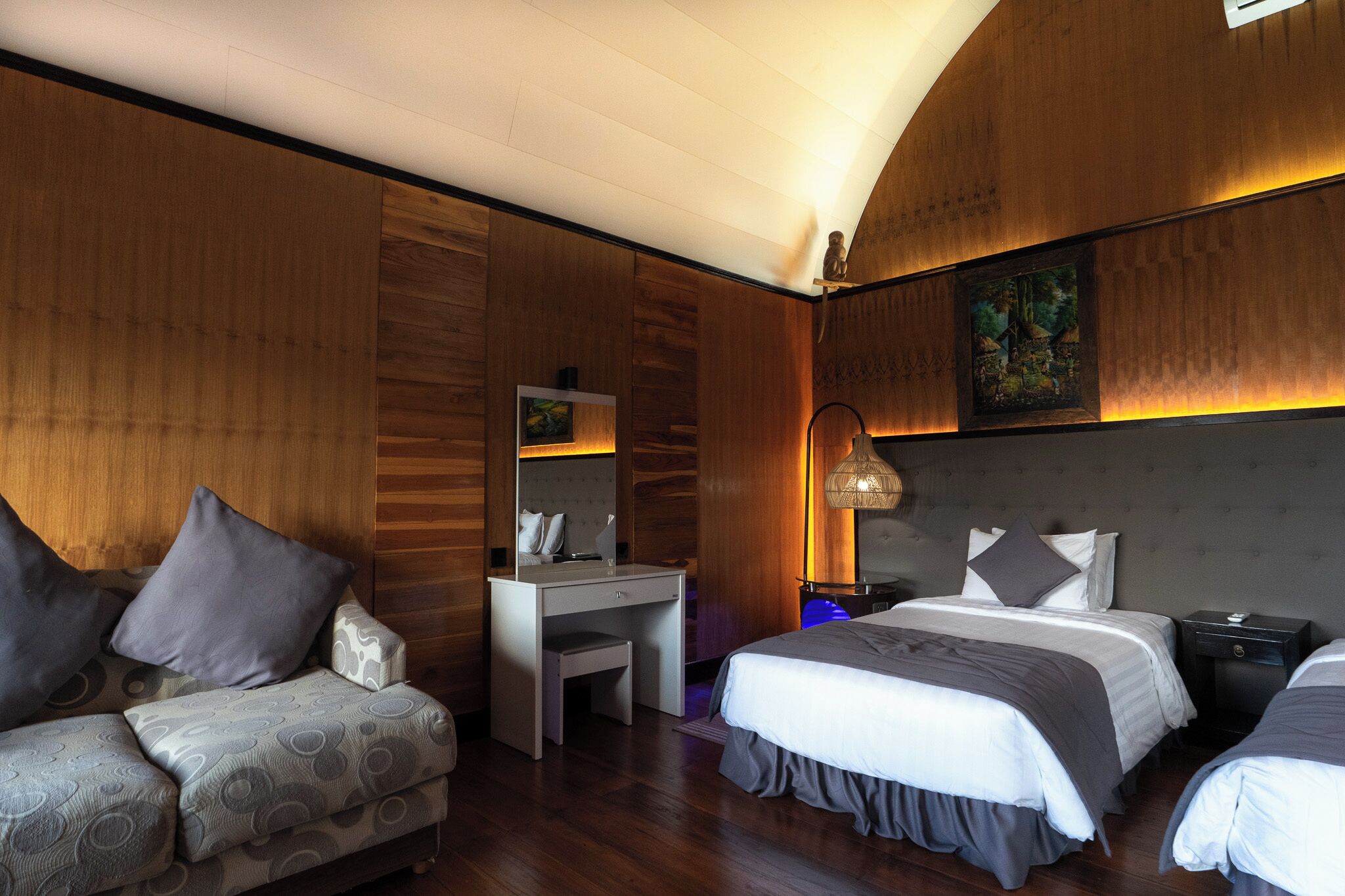 Una habitación de hotel con una pared de madera, un escritorio, una cama y un sofá.