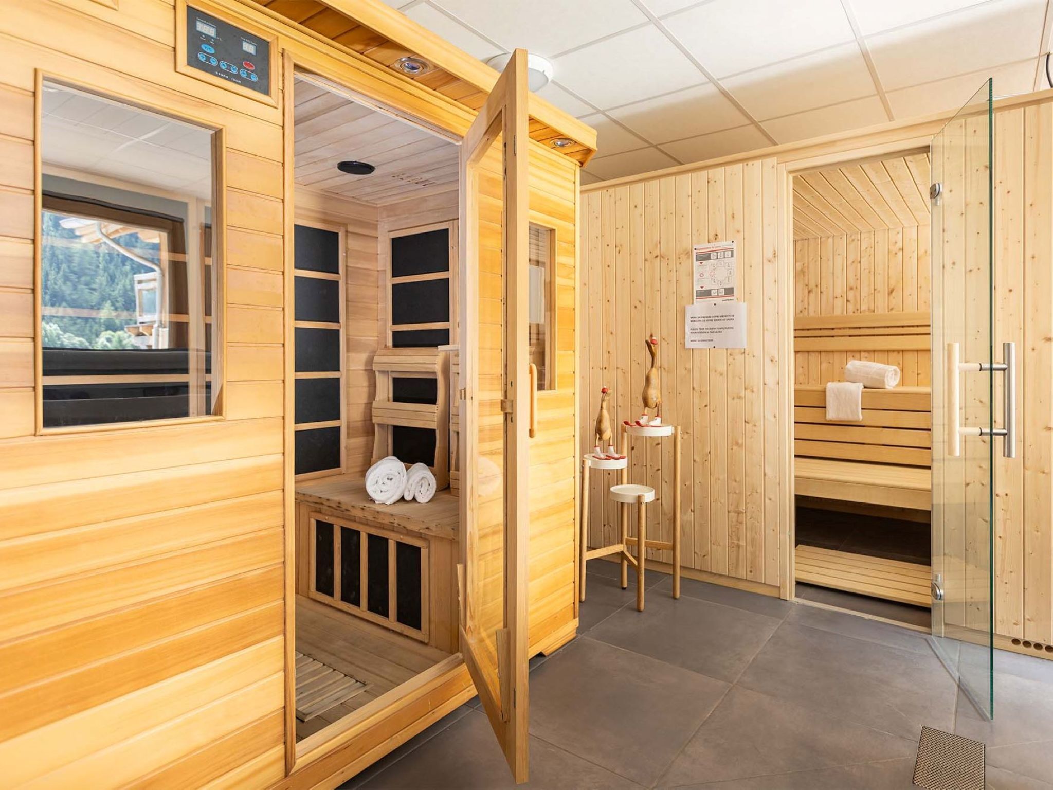 A sauna room with wooden walls, a bench, and a small table with towels.