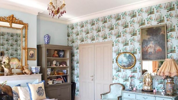 A room with a vintage aesthetic, featuring a large mirror, a chandelier, a floral wallpaper, and a classic wooden cabinet. - Bed and Breakfast for Two (MOULEYDIER)