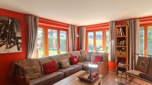 A living room with a large sectional sofa, a wooden coffee table, and a bookshelf.