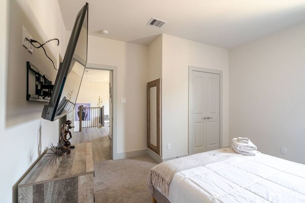 A bedroom with a bed, a dresser, a mirror, and a door. - Vibrant 3 Beds 2 bedroom House 15min from HOU (Houston)