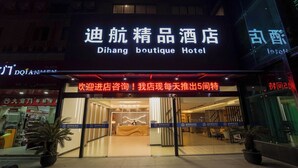 Exterior del Hotel Dihang Boutique, con un área de recepción visible a través de las puertas de vidrio.