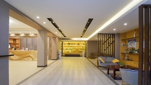 Un moderno vestíbulo de hotel con mostrador de recepción, zona de estar e interior bien iluminado.
