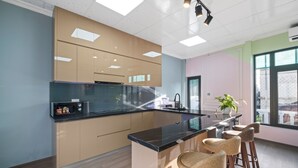 Una cocina moderna con una isla central, taburetes de bar y un amplio ventanal que proporciona luz natural.
