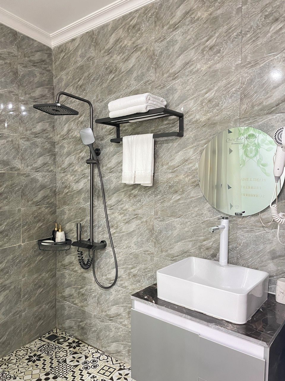 A modern bathroom with a shower, a sink, and a mirror.