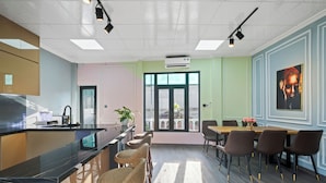 Una cocina moderna con encimera de mármol, taburetes de bar y una zona de comedor con mesa y sillas.