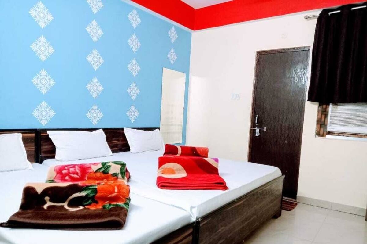 Habitació d'hotel amb llit, porta i finestra amb cortines.