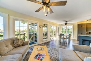 Relax in a spacious living area with a high ceiling fan, sofa, and dining table.