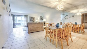 A spacious living room with a dining area, a sofa, and a table with chairs.